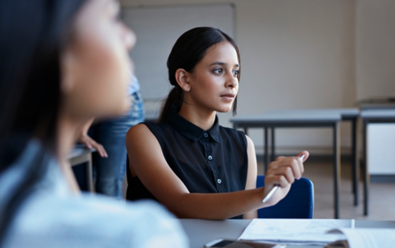 women in an office listening and writing