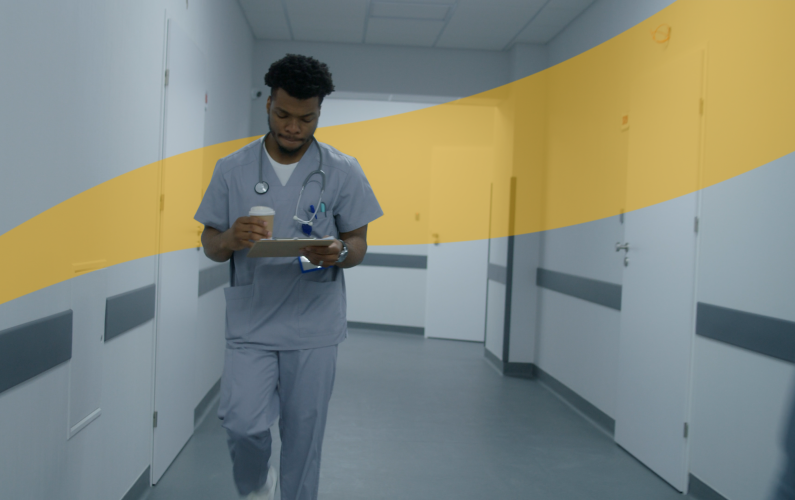 resident holding coffee and clipboard walking down corridor