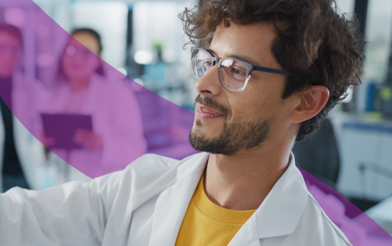 student in lab coat writing on white board