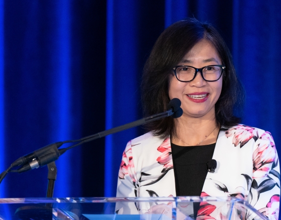 woman standing at podium smiling