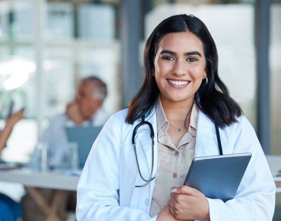 medical student holding tablet and smiling