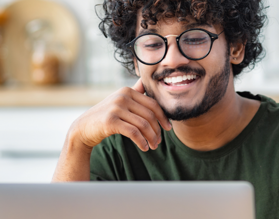 student working at laptop and smiling
